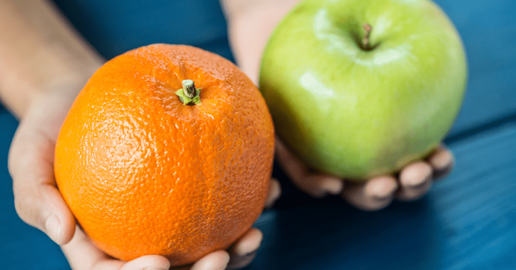 two hands holding an apple and an orange